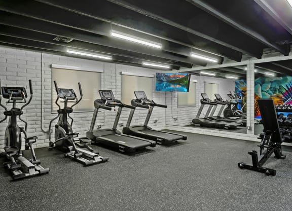 a spacious fitness center with treadmills and other exercise equipment