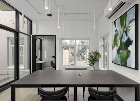 A modern conference room with a long table and chairs.