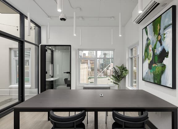 A modern conference room with a long table and chairs.