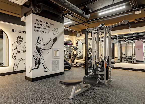 A gym with a sign that says "There is no way around the way hard work embraces it.".