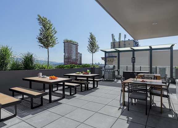 A patio with tables and chairs is set up on a tiled floor.