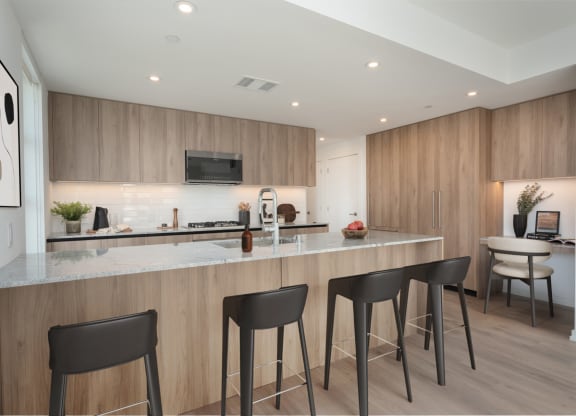 a kitchen with a marble counter top and three stools