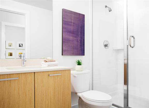 A bathroom with a toilet, sink, and a purple wall hanging.