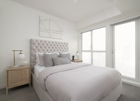 a white bedroom with a large bed and a window