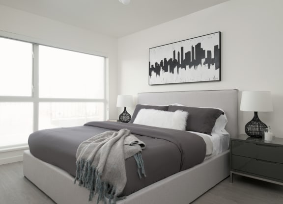 a black and white bedroom with a bed and a large window