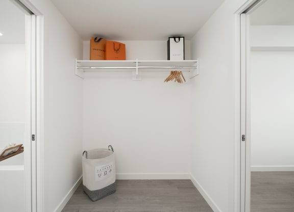 a small laundry room with a basket and shelves on the wall