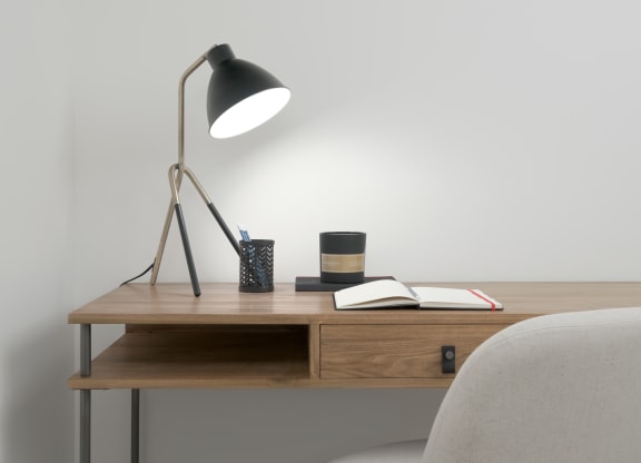 a desk with a lamp and a chair in a room