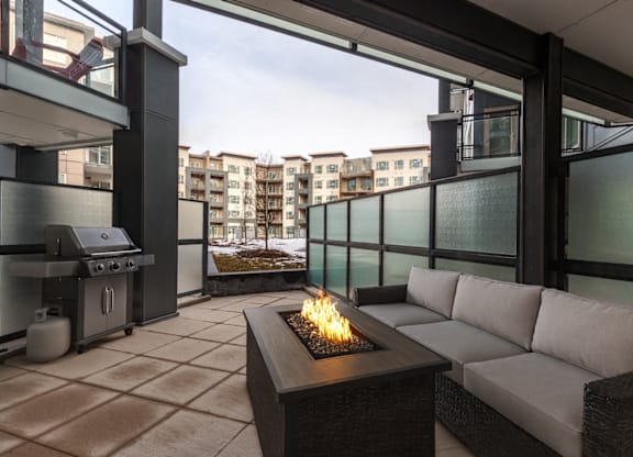 A patio with a fire pit and seating area.