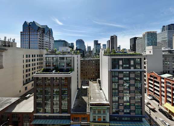 A cityscape with buildings of various designs and a clear sky.