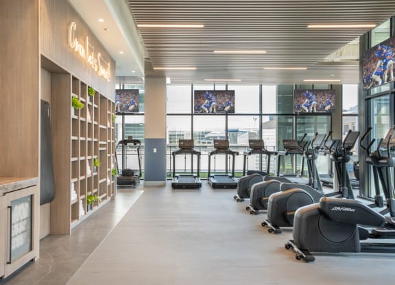 a row of treadmills and elliptical trainers in a gym