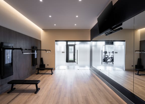 a gym with wood floors and a large screen tv on the wall