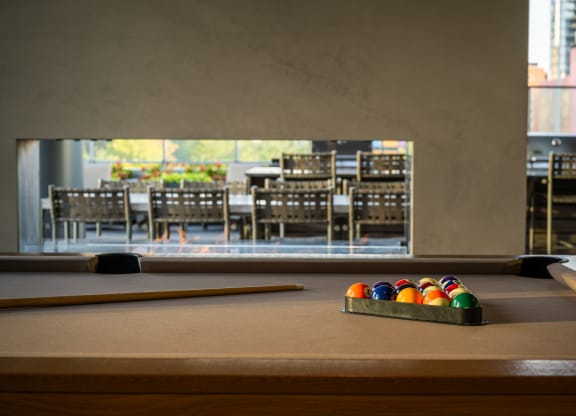 a pool table with a view of a dining room in the background