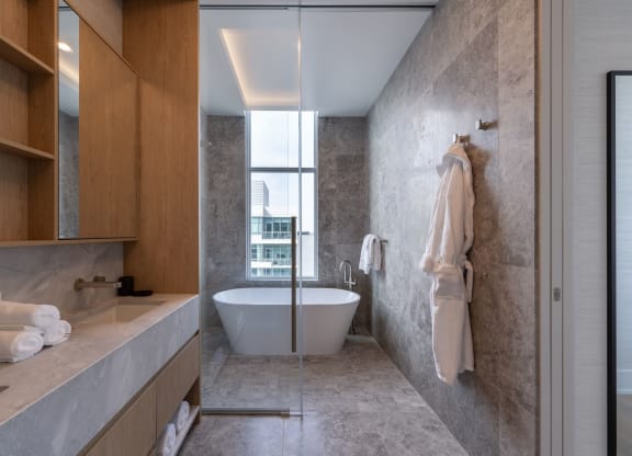 a bathroom with a white bathtub and a large window