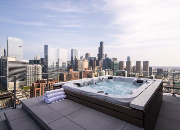 an outdoor jacuzzi on a balcony with a view of the chicago skyline