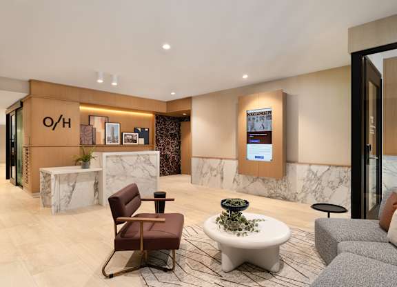 A reception area with a brown chair and a white table.