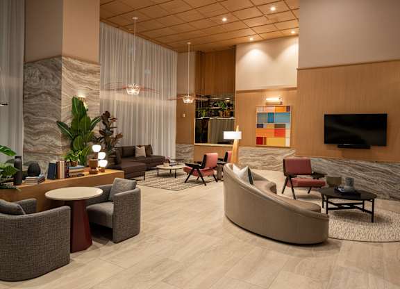 A living room with a sofa, chairs, and a TV.