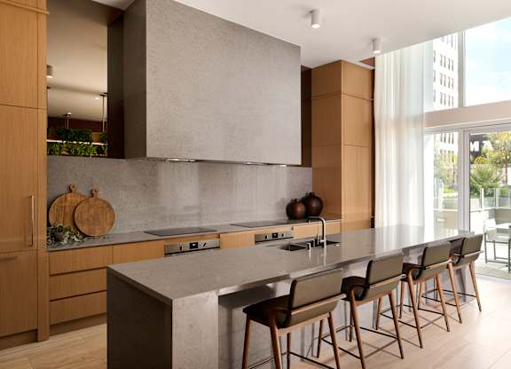 A modern kitchen with a long island and chairs.