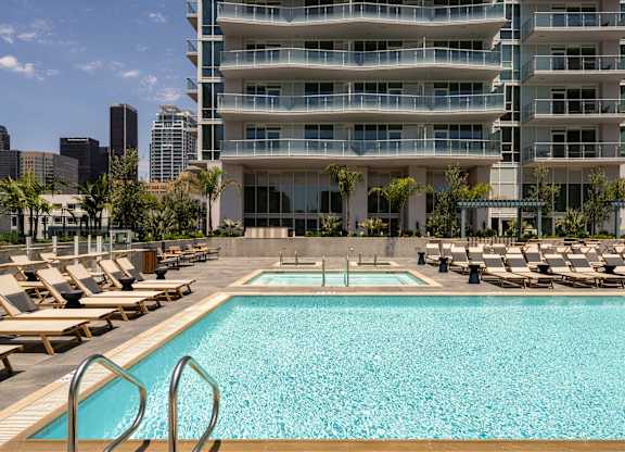 A large swimming pool in front of a multi-story building.