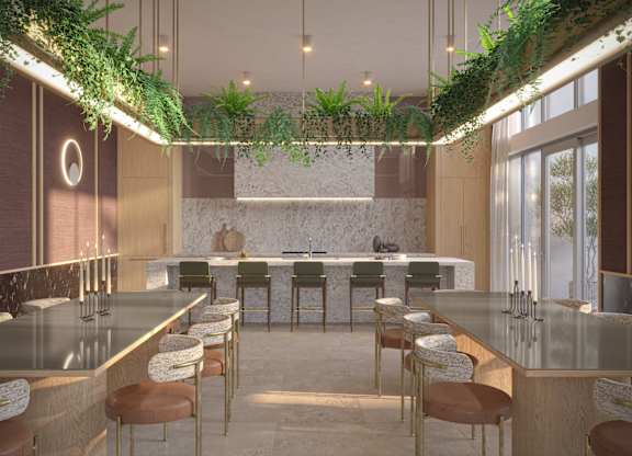 A modern kitchen with a long counter and bar stools.