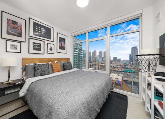 A bedroom with a large bed and a view of the city.