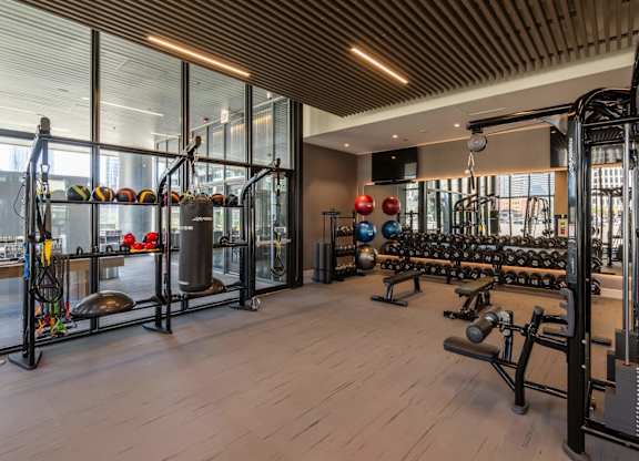 A gym with a variety of equipment including weights and weight machines.