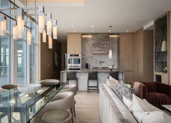A modern living room with a glass table and a long white sofa.