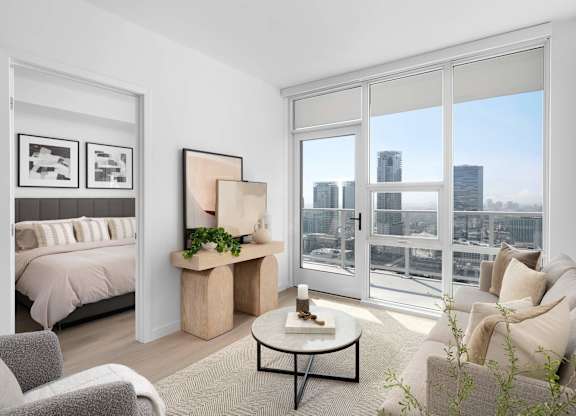 A modern living room with a view of the cityscape outside the sliding glass doors.