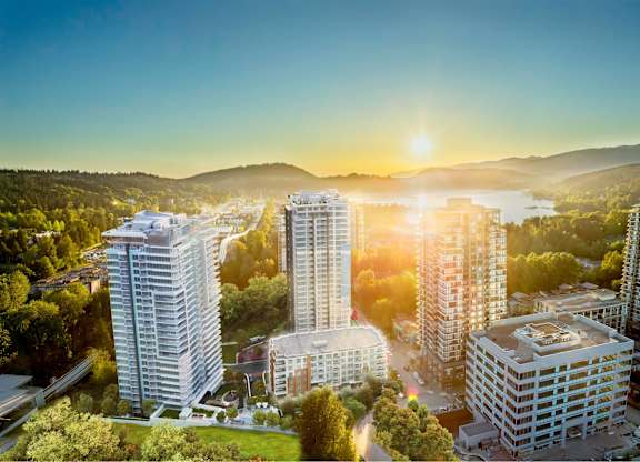 A cityscape with buildings and greenery under a clear sky.