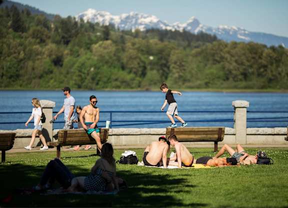 A group of people are relaxing on a sunny day by the water.