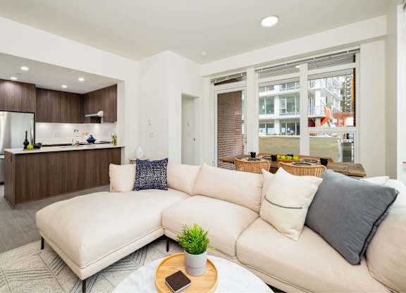 A modern living room with a white sofa and a wooden coffee table.