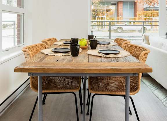 A dining table with chairs and a tablecloth is set for a meal.