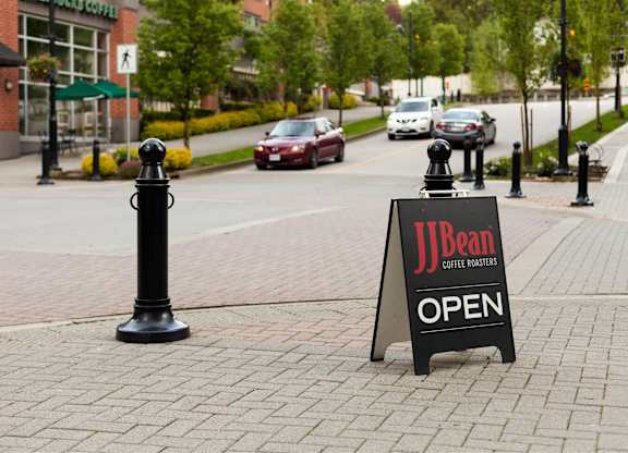A sign that says JBean Coffee Roasters is on the sidewalk.
