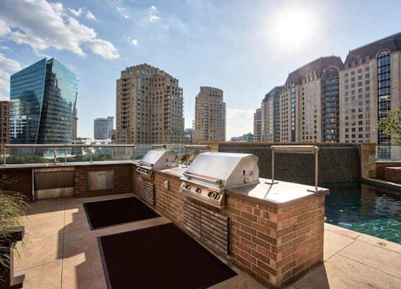 A sunny day in a city with a pool and a building with a white roof.