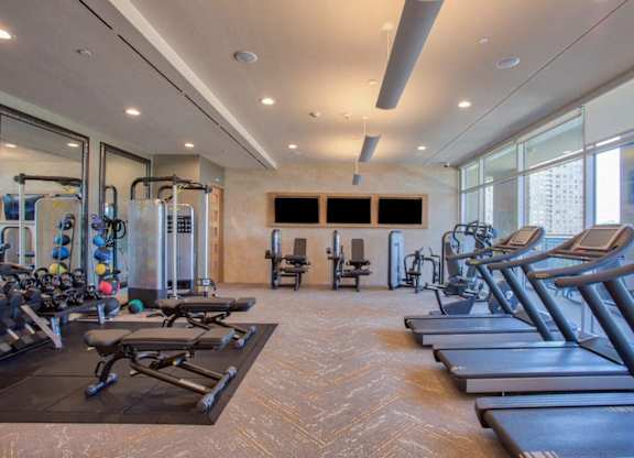 A gym with treadmills, weights, and exercise equipment.