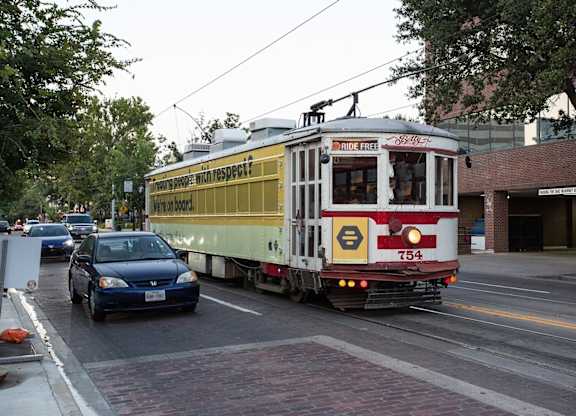 A streetcar with a sign that says "ride free" is on a city street.