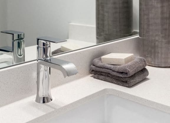 a bathroom sink with a mirror and a soap dispenser