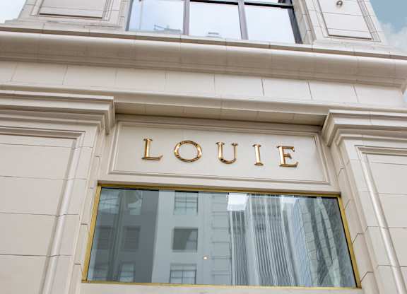 A building with a window and the word LOUIE on it.