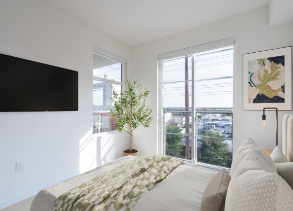 a bedroom with a bed and a tv on the wall