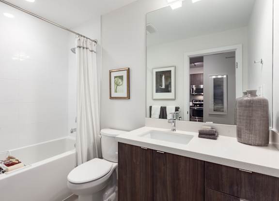 A white bathroom with a toilet, sink, and bathtub.