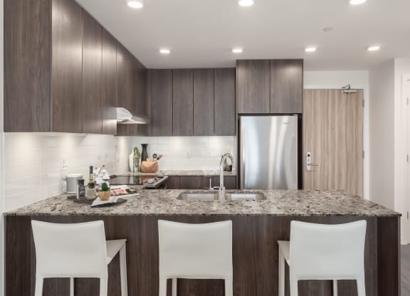 a kitchen with a granite counter top and a stainless steel refrigerator
