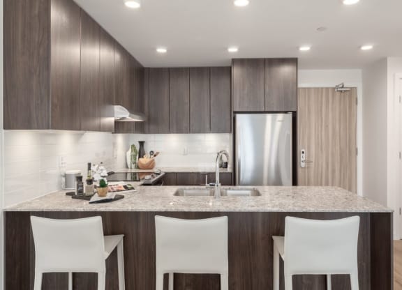 a kitchen with a marble counter top and wooden cabinets