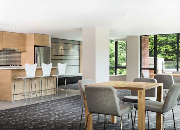 A modern dining area with a wooden table and grey chairs.