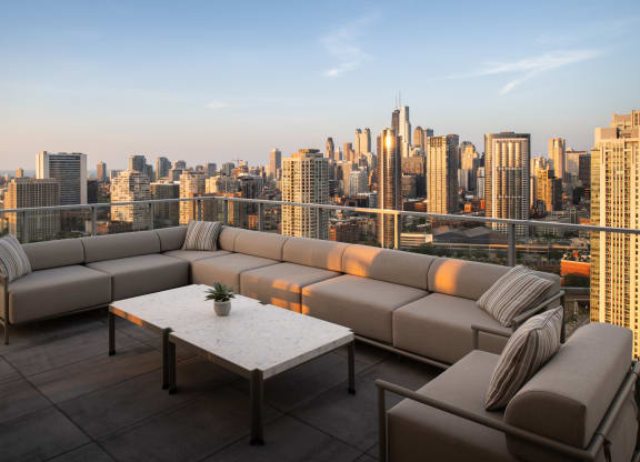 a terrace with a couch and a table overlooking a city