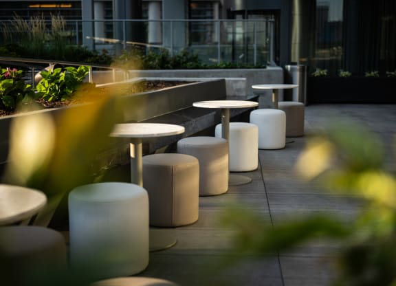 a row of tables and stools on a terrace