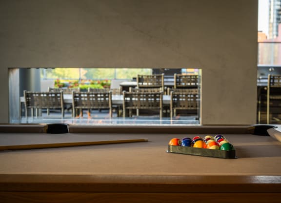a pool table with a view of a dining room in the background