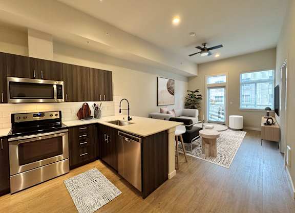 A modern kitchen with stainless steel appliances and wooden cabinets at B Flats Apartments, Bremerton, 98337