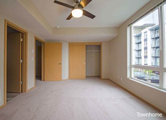 A room with a ceiling fan and carpeted floor at Spyglass Hill Apartments, Bremerton, 98337