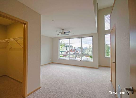 A room with a carpet floor and a ceiling fan at Spyglass Hill Apartments, Bremerton, Washington