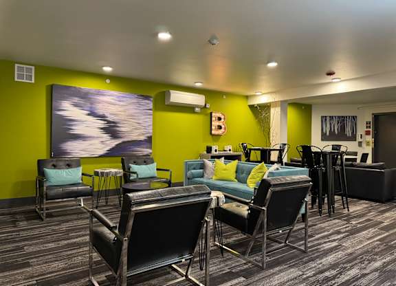A room with a green wall and a large painting of a cloudy sky at B Flats Apartments, Bremerton, 98337
