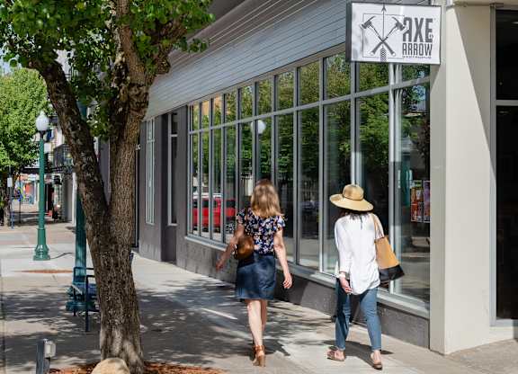 Two women walking past a storefront with a sign that read at B Flats Apartments, Bremerton, 98337